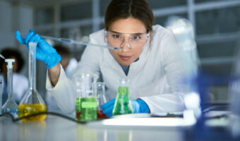 Female chemist working on medical research in laboratory.
