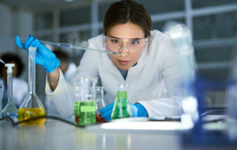 Female chemist working on medical research in laboratory.